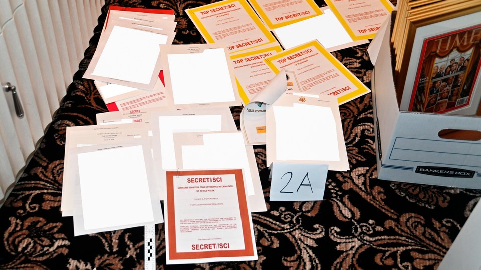 A photograph from DOJ's filing showing documents marked as classified on the floor