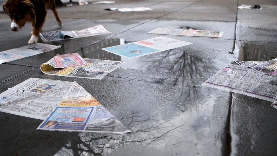 A discarded newspaper on the wet ground