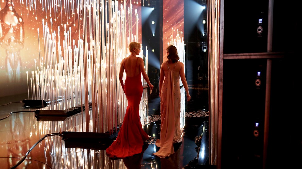 Two presenters walking offstage at the Oscars