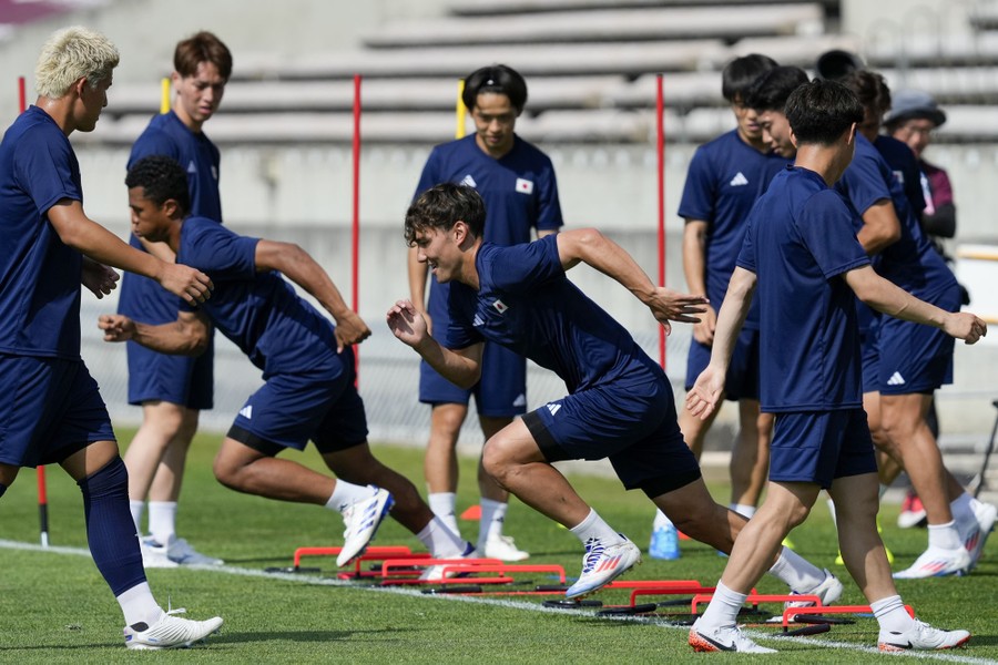 Soccer players run sprints during a training session.