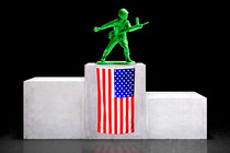 An illustration of a green toy soldier standing atop a victory podium with a draped American flag