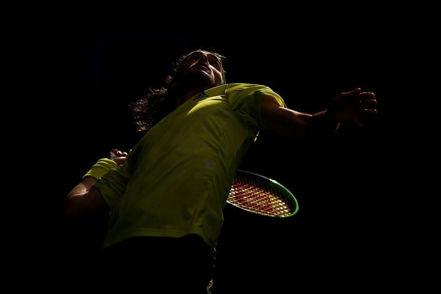 Stefanos Tsitsipas reaches back to serve.