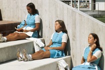 Three girls sitting under three flags