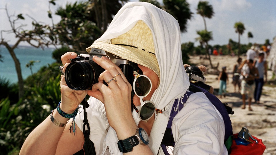 A tourist taking a photograph on a beach