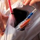 Photograph of a kid with a smartphone and pens in their shirt pocket