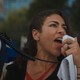 Maryam Henein at a protest, yelling into a megaphone