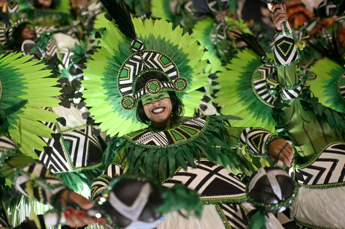 Dancers in colorful costumes and make up perform in a parade.