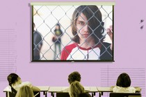 A frame from the documentary "Bad Kids" fills the screen of a projector in a classroom.