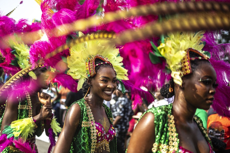 People wear colorful costumes while taking part in a parade.