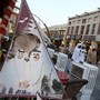 People walk past a banner bearing portraits of Qatar's former emir, Sheikh Hamad bin Khalifa al-Thani, and his son Sheikh Tamim.