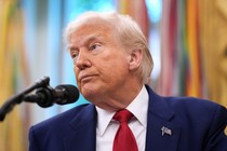 Donald Trump looks off to the side with a microphone in front of him
