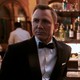 Daniel Craig and Ana de Armas dressed in black cocktail attire at a bar for a scene in 'No Time to Die'
