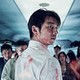 A still from the movie "Train to Busan" showing a bloodied man on a train with other passengers