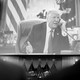 Black-and-white picture of screen showing then-President Donald Trump speaking on the phone from his desk at the Oval Office.