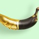An illustration showing a rotten banana painted in gold