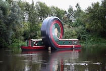 An art installation made of a canal boat that has apparently been twisted into a loop in the middle