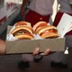 a photo of a man holding a box of hamburgers