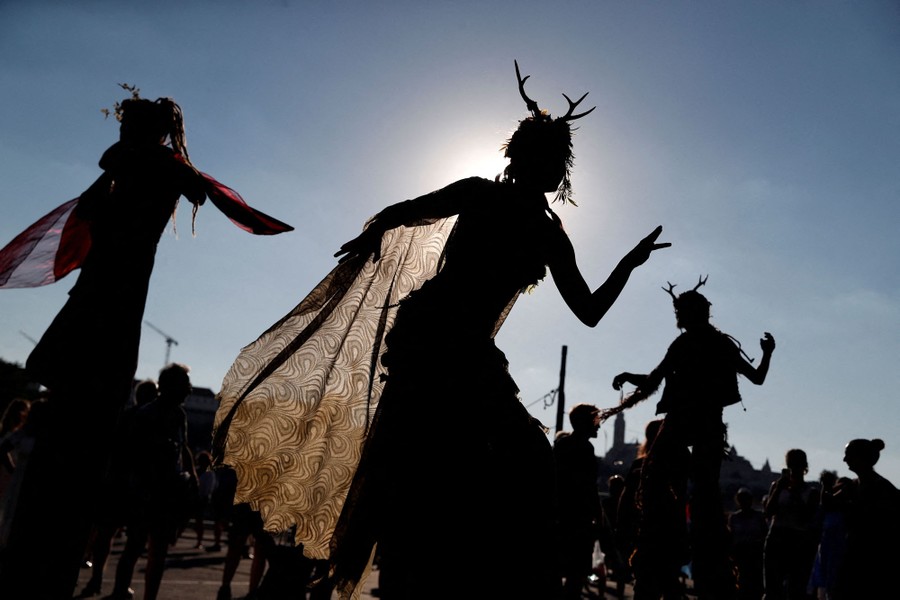 Several performers in silhouette, dancing during a protest