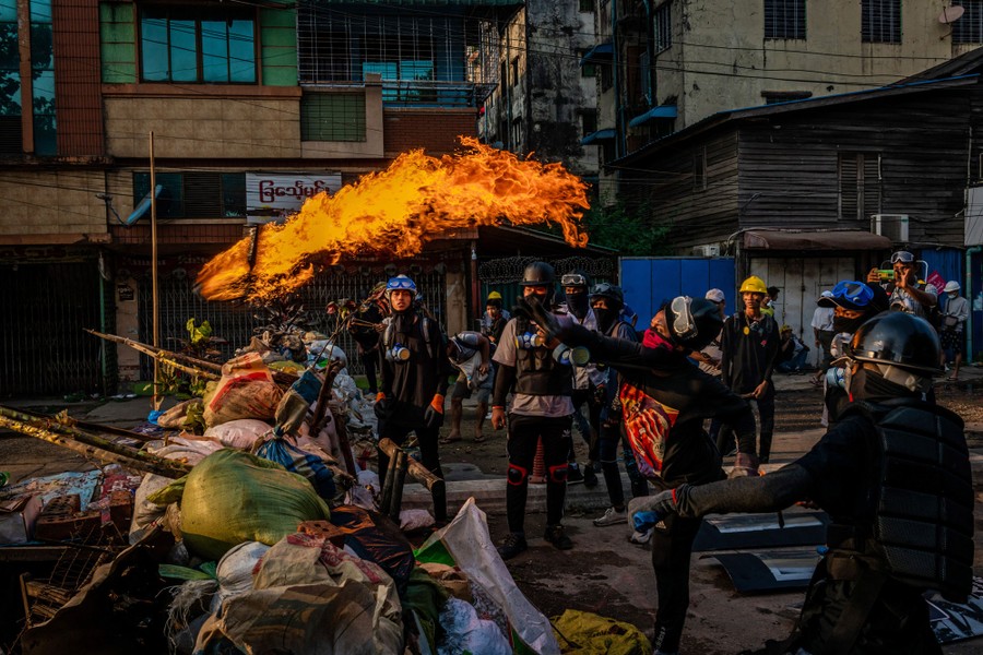 Protesters toss a burning Molotov cocktail.