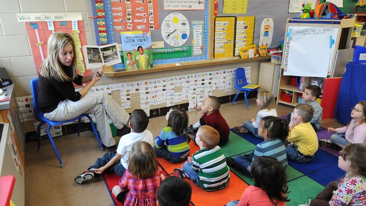 A teacher reads to sitting schoolchildren