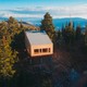 An unfinished house with a slanted roof on a mountain among trees