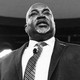 Black-and-white photo of Mark Robinson with a microphone attached to his tie