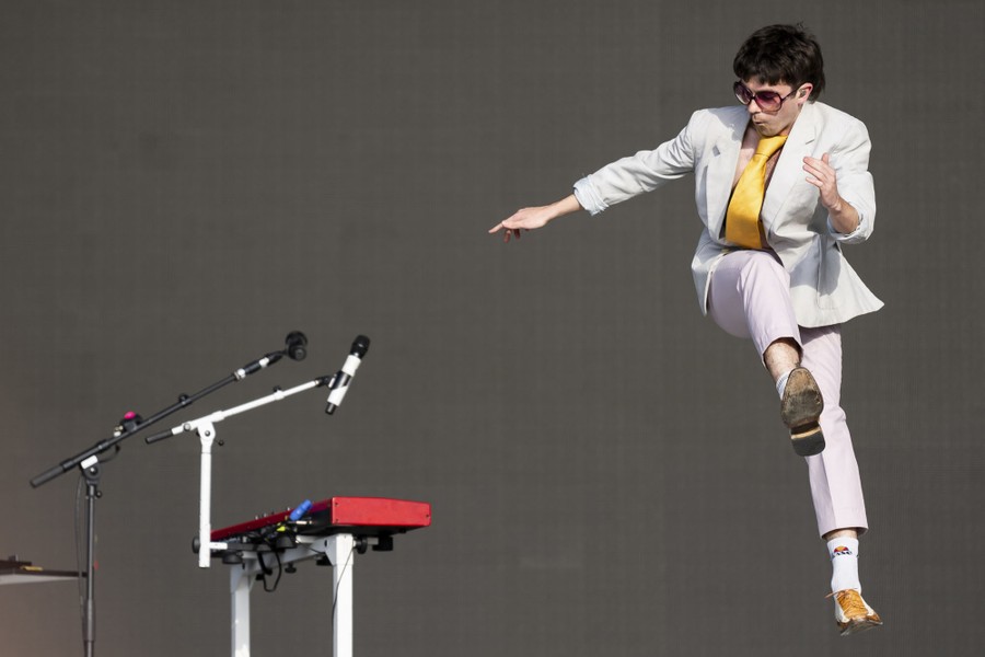 A musician jumps while performing onstage.