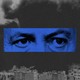A blue rectangle with a close up photo of Netanyahu's eyes is superimposed on a black and white shot of smoke rising over an Iranian city.