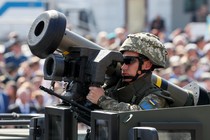 A Ukrainian army service member rides in an armored vehicle with a Javelin anti-tank missile during a parade to celebrate Ukraine's independence.