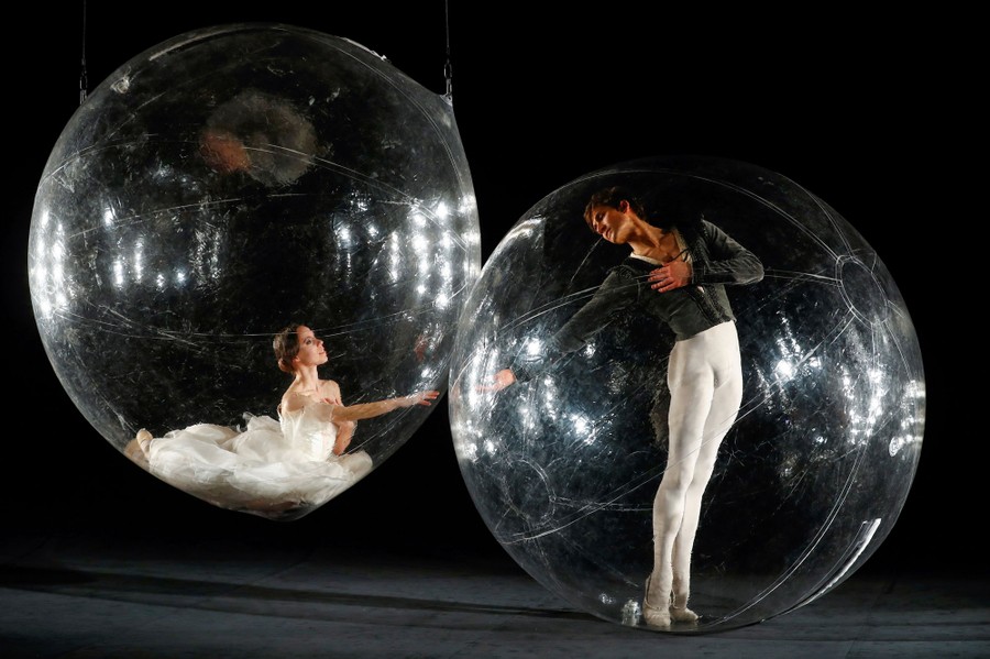 Two dancers perform together, each inside their own 6-foot-diameter clear plastic bubble.
