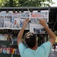 A vendor adjusts the front pages of the Greek newspapers, which refer to the election result