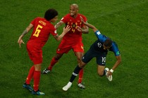 Three soccer players shoving each other