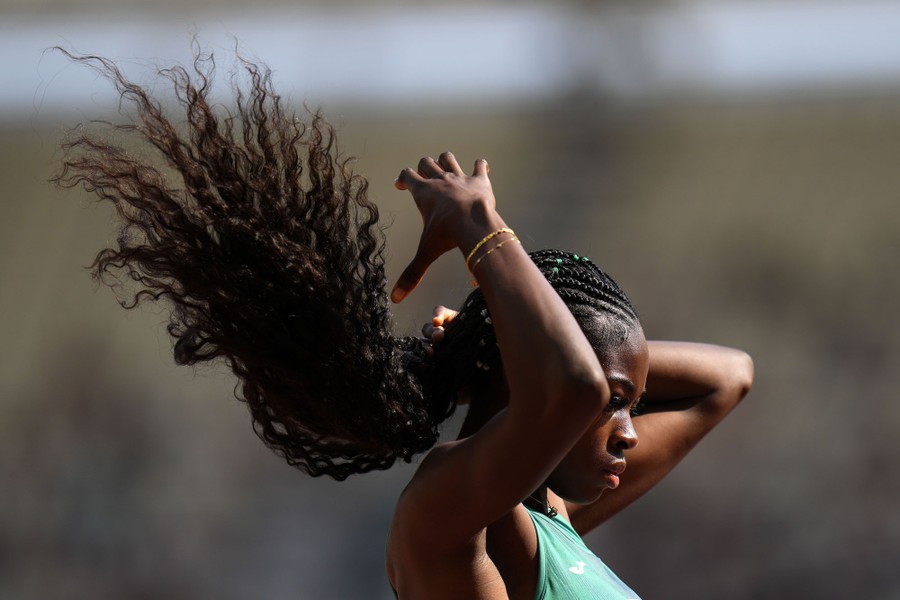An athlete adjusts their long hair before a race.