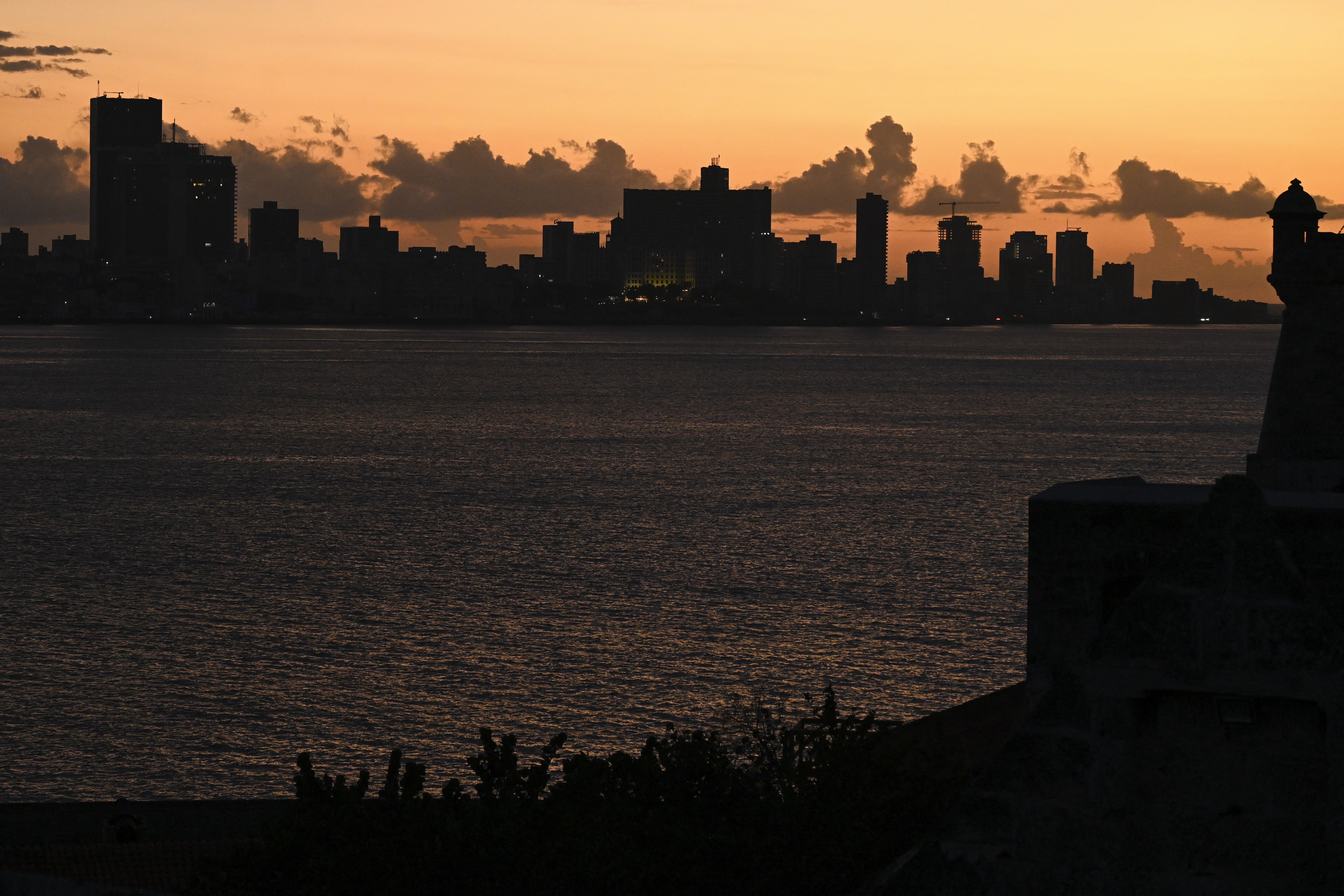 A dark city skyline, seen at sunset during a blackout
