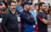 A landscape photo of Ted Lasso, Coach Beard, and Roy Kent from the TV show "Ted Lasso"