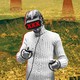 A man wearing a cable-knit sweater wears virtual-reality goggles labeled "XXX."