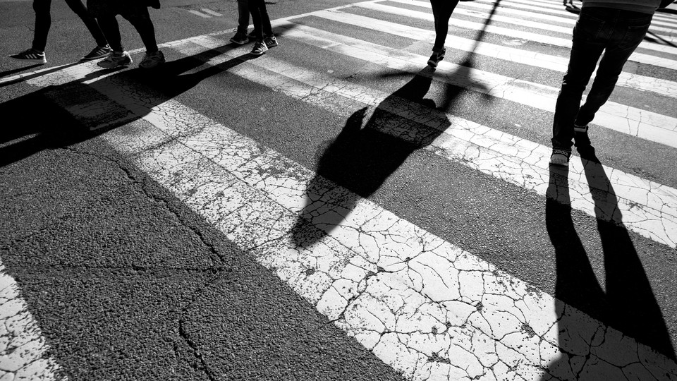 A photo of a pedestrian crossing in black and white.