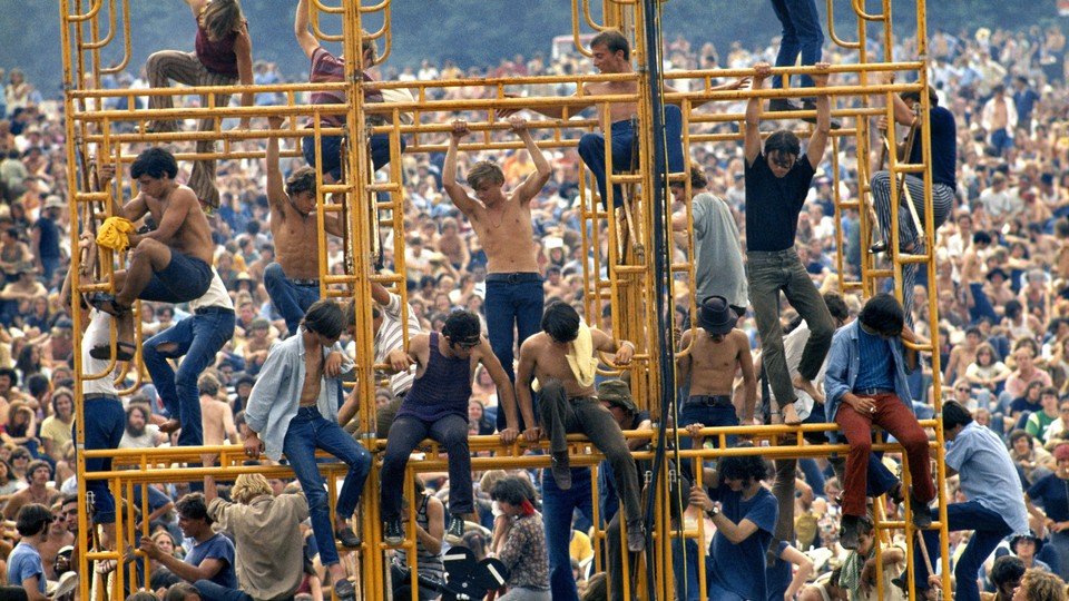 Woodstock attendees sitting on the sound tower.