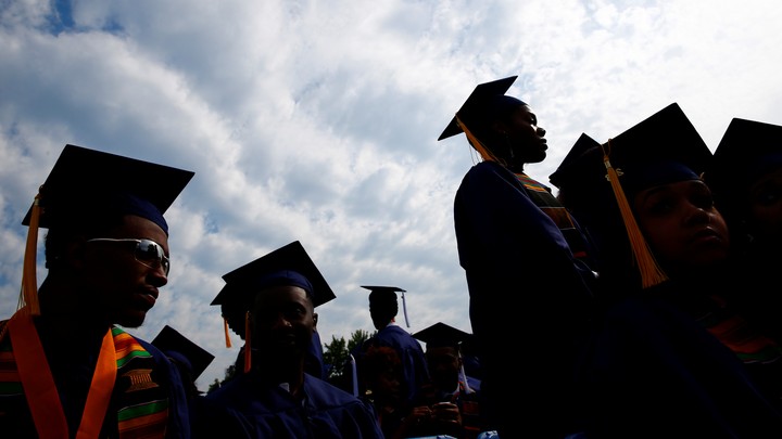 People in graduation caps sit together.