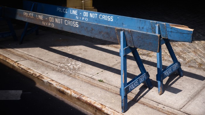 Two police barricades on the sidewalk