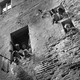 A family looks outside the window of their apartment in Siena, Italy.