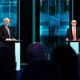 Boris Johnson and Jeremy Corbyn stand on a TV debate stage.