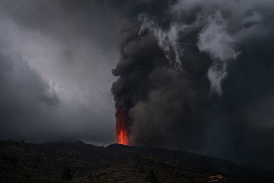 Dark skies are seen above an erupting volcanic fissure.
