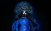 Björk in a blue gown with a large headdress