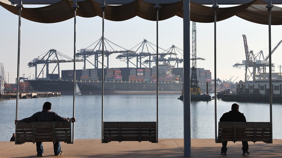 Men wait alone on benches at a port.