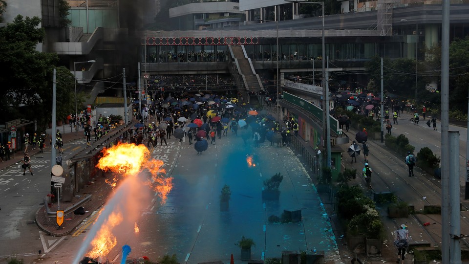 Riot police spray blue-colored water during a protest on China's National Day in Hong Kong.