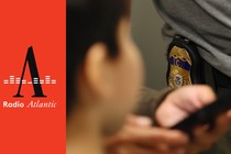 A child looking at the ICE officer's badge