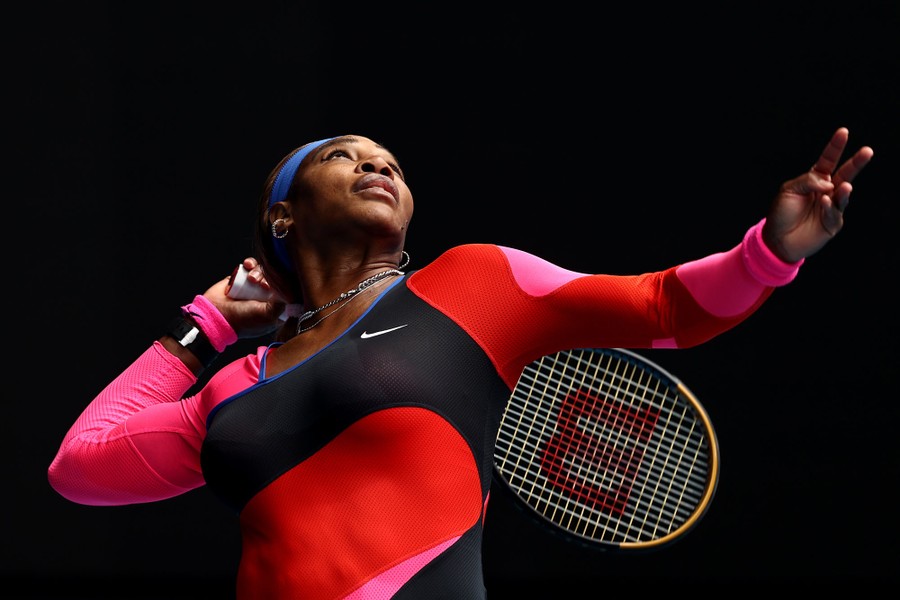 Serena Williams reaches back with her racket to serve a ball.