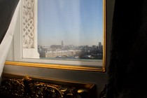 Moscow is seen through the window of a darkened hotel room.