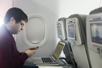 A man using his laptop on the plane